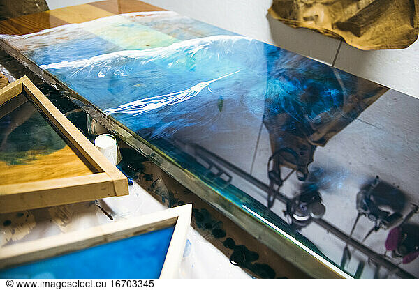 Detail of reflective resin artwork drying in art studio