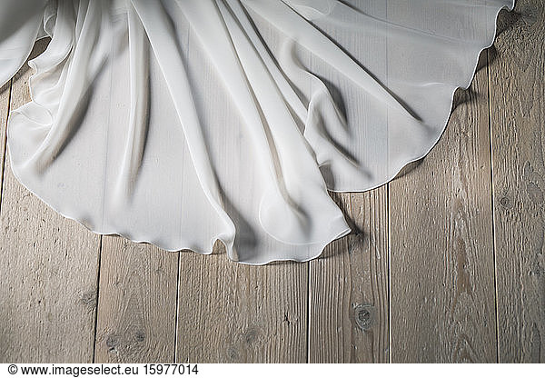 Detail of wedding dress on wooden floor