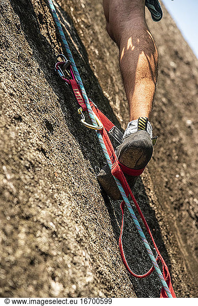 Detail von Bergsteigerschuhen und Füßen auf künstlichem Steigbügel