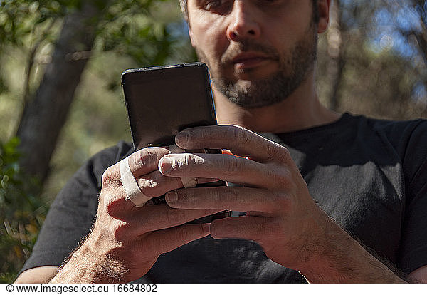 Details of the fingers of a climber that consult the mobile.