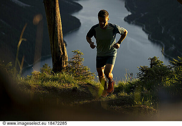 Determined athlete jogging on mountain at sunset