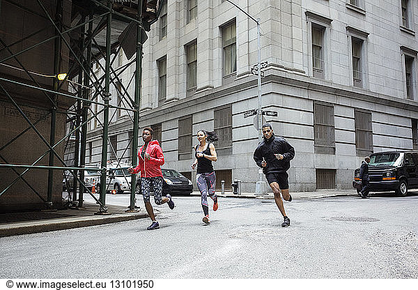 Determined athletes jogging on city street