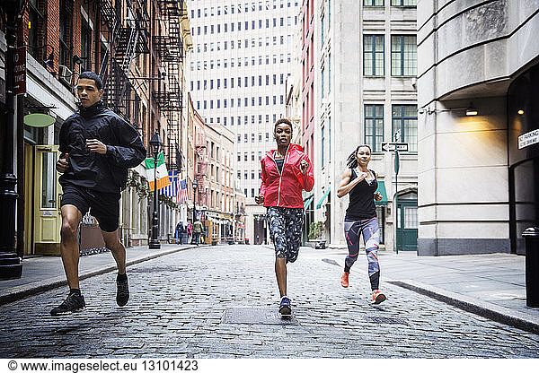 Determined athletes running on city street