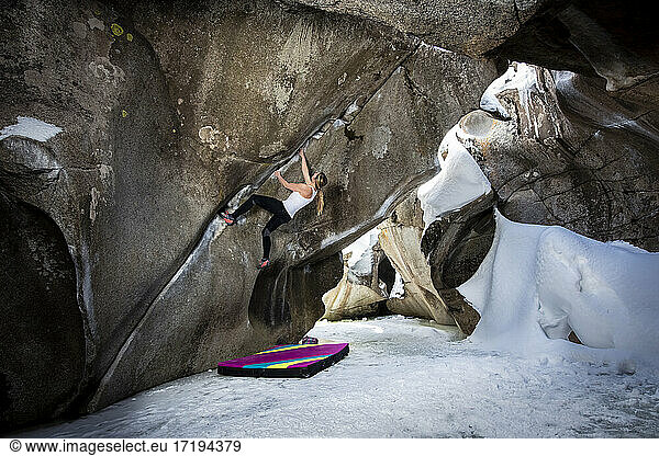 Determined female bouldering in ice caves at Independence Pass