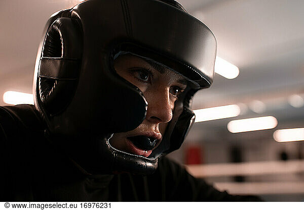 Determined female boxer in protective gear ready for fight