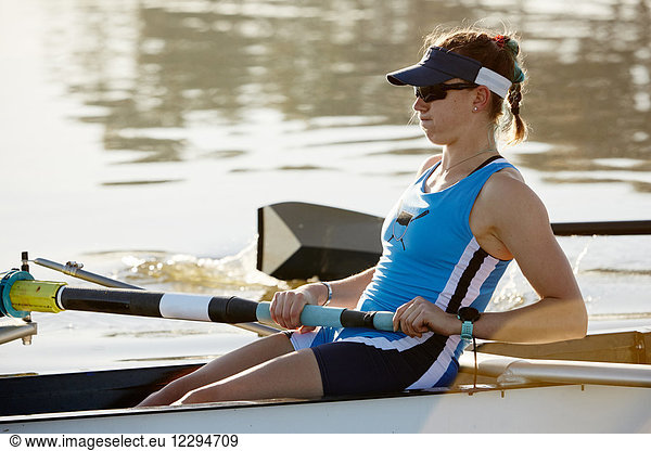 Determined female rower rowing scull