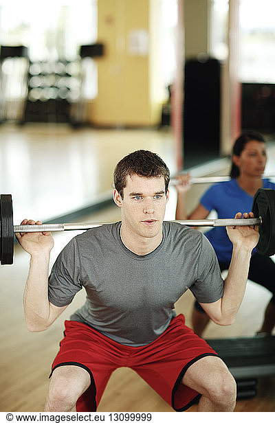 Determined male athlete lifting barbell in gym