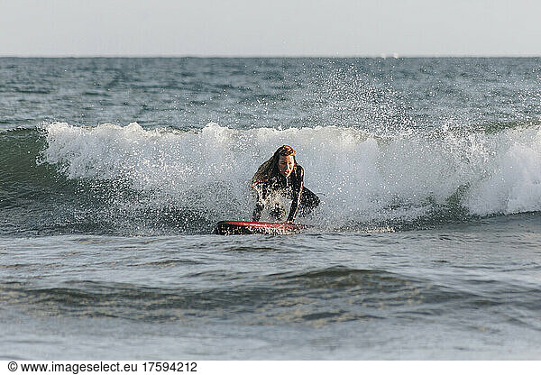 Determined woman surfing in front of wave in sea  Gran Canaria  Canary Islands