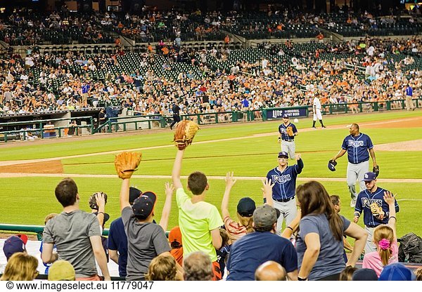 Detroit  Michigan - A baseball player for the Tampa Bay Rays tosses a ball to children in the stands at the end of an inning at Comerica Park  home of the Detroit Tigers.
