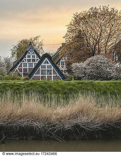 Deutschland Altes Land Jork Idyllische ländliche Szene mit Fachwerkhäusern im Frühling bei Sonnenuntergang