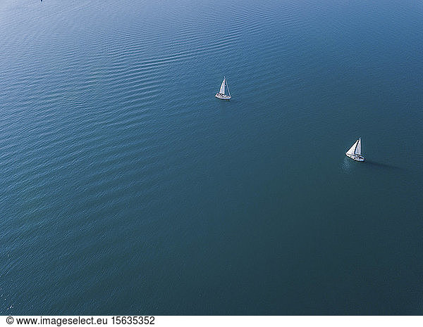 Deutschland  Bayern  Luftaufnahme von zwei Segelbooten  die Ã?ber das blaue Wasser des Chiemsees segeln
