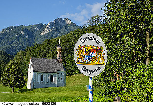 Deutschland  Bayern  Nussdorf  Landesgrenzhinweisschild mit Kreuzkirche im Hintergrund