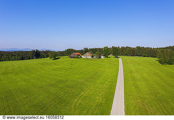 Deutschland  Bayern  Reit im Winkl  Drone view of dirt road leading to small countryside village in spring