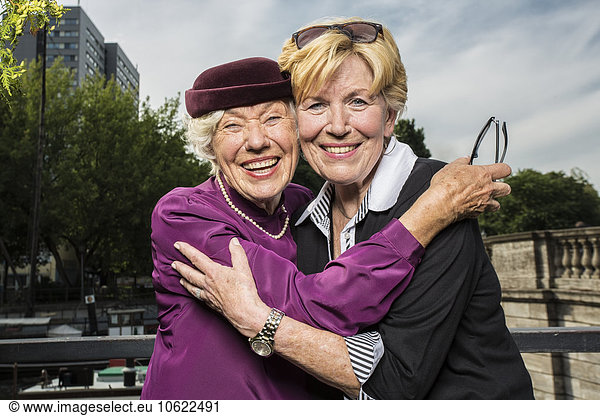 Deutschland  Berlin  Porträt von zwei glücklichen Seniorinnen Kopf an Kopf