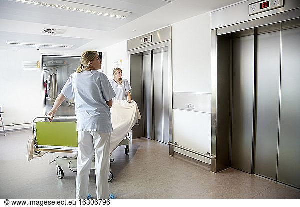 Deutschland  Freiburg  Krankenschwestern bewegen Krankenhausbett