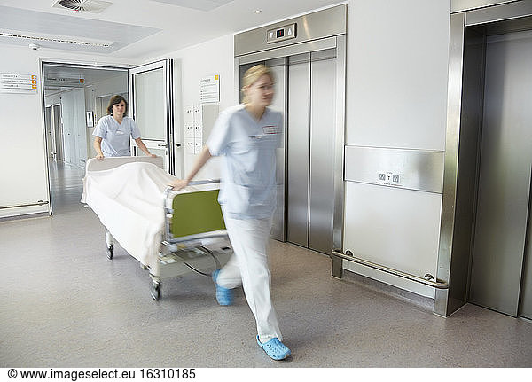 Deutschland  Freiburg  Krankenschwestern bewegen Krankenhausbett
