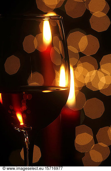 Deutschland  Glas Rotwein mit Weihnachtsbeleuchtung im Hintergrund