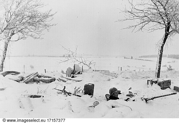 DEUTSCHLAND -- 29. Januar 1945 -- Amerikanische Soldaten rücken von Belgien aus nach Deutschland vor; ein Maschinengewehrschütze des 26. Infanterieregiments der 1. Infanteriedivision bewacht einen Straßenabschnitt  der gerade von seiner Einheit eingenommen wurde -- Bild von Lightroom Photos / US Army ***Beste verfügbare Qualität. NB Nicht retuschiert für Staub  Kratzer.