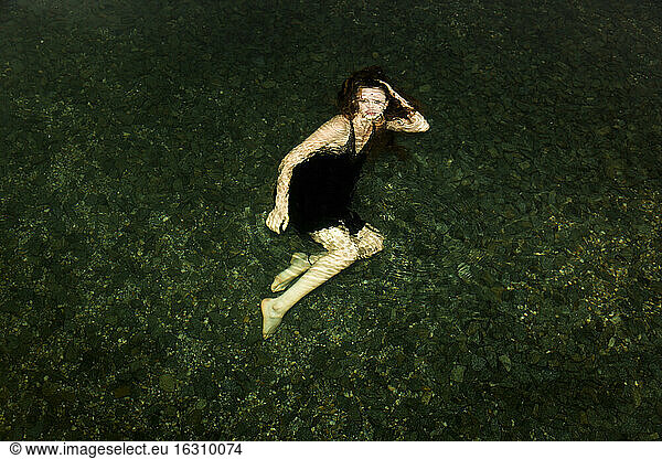 Deutschland  Junge Frau unter Wasser  Blick in die Kamera