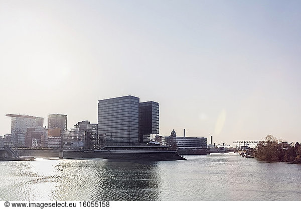 Deutschland  Nordrhein-Westfalen  Düsseldorf  Sonnenschein über Medienhafen mit Stadttor im Hintergrund