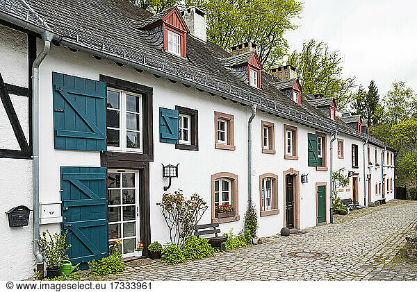 Deutschland  Nordrhein-Westfalen  Kronenburg  Rustikale Häuserzeile entlang einer Kopfsteinpflasterstraße in einem historischen mittelalterlichen Dorf