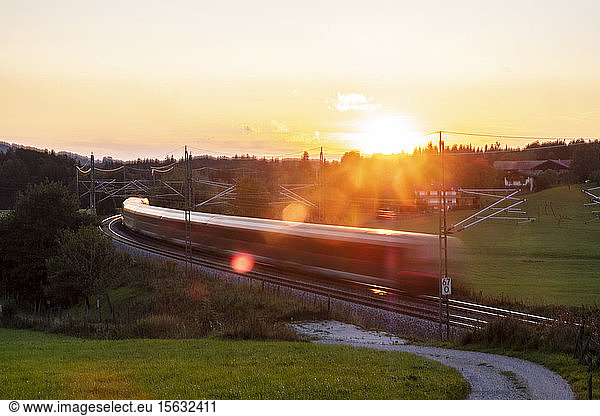 Deutschland  Oberbayern  Regionalzug bei Sonnenuntergang
