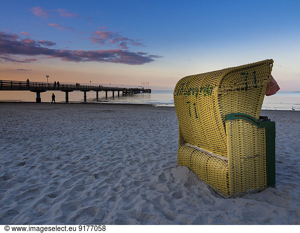 Deutschland Schleswig-Holstein Scharbeutz Seebrücke Strandkorb am Strand am Abend