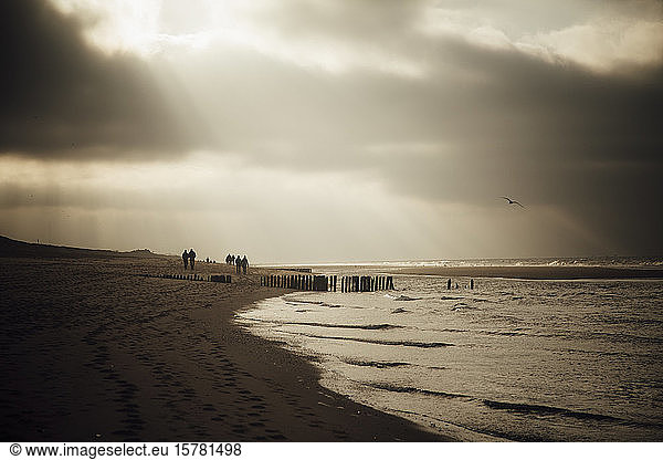 Deutschland  Schleswig-Holstein  Sonnenlicht durchdringt Wolken über dem Sandstrand der Insel Sylt in der Abenddämmerung