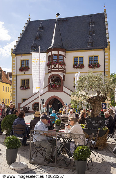 Deutschland  Unterfranken  Volkach  Menschen im Café am Marktplatz mit Rathaus im Hintergrund