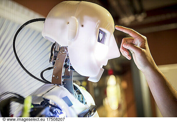 Developer touching human robot on head at workshop