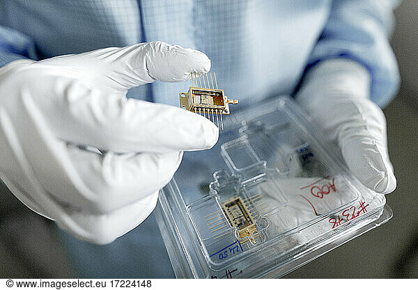 Die Hände eines männlichen Wissenschaftlers beim Auspacken von Laserchips