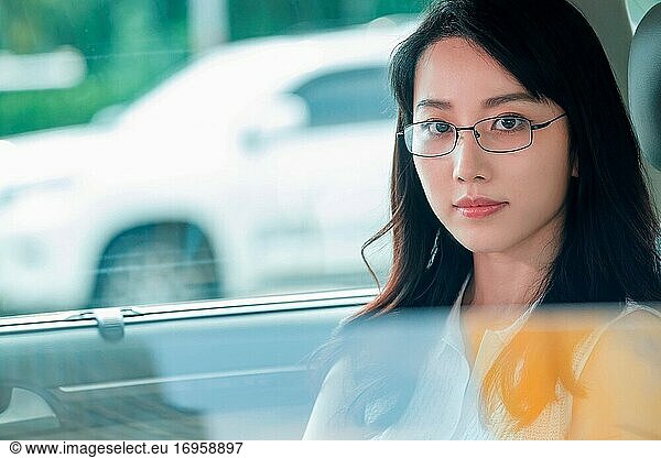 Die intellektuelle junge Frau saß im Auto