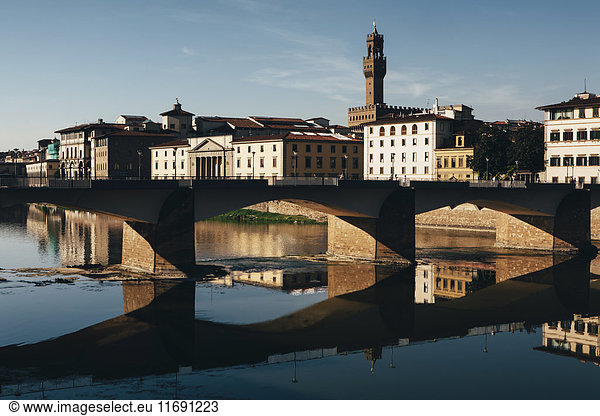 Die Ponte alle Grazie  historische Brücke über das flache  ruhige Wasser des Arno  mitten in Florenz.