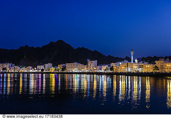 Die Stadt Muscat  Lichter am Wasser  Berge dahinter  bei Nacht
