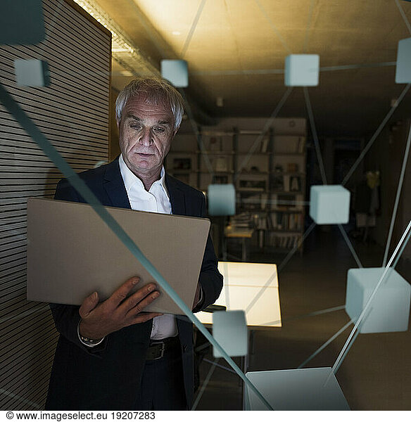 Digital composite image of businessman using laptop in office