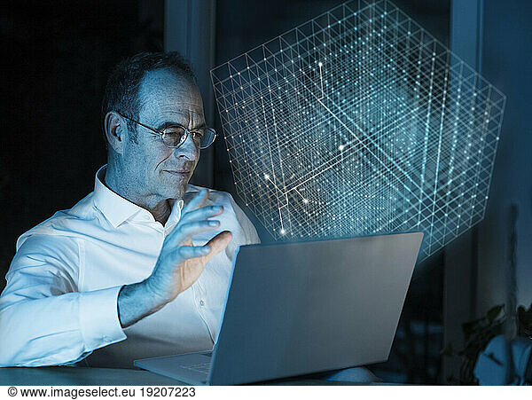 Digital composite image of businessman using laptop with 3D cube in office