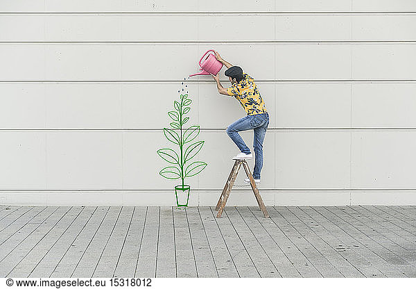Digital composite of young man watering flower at a wall