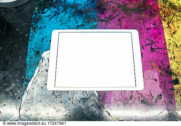 Digital tablet on multi colored scratched table