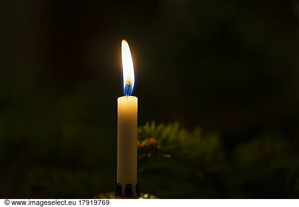 Dim light from a single candle in the dark  Christmas lighting  symbolic image save electricity  power failure  blackout