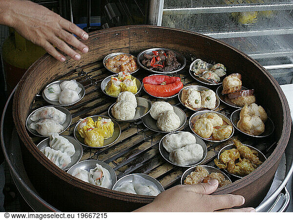 Dim sum in a bamboo steamer is prepared for customers.