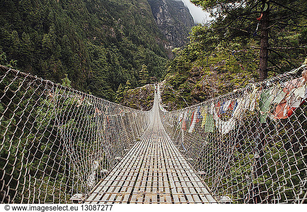 Diminishing perspective of footbridge amidst mountains at Sagarmatha National Park