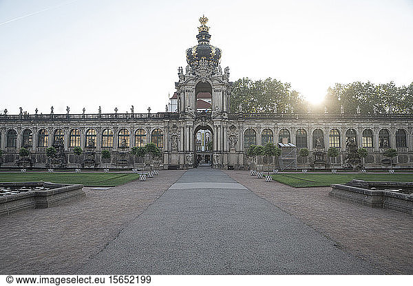 Diminishing perspective of footpath leading towards Zwinger against clear sky at sunset  Saxony  Germany