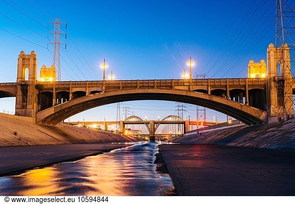 Diminishing perspective of Los Angeles river and 4th and 6th street bridges in the evening  Los Angeles  California  USA