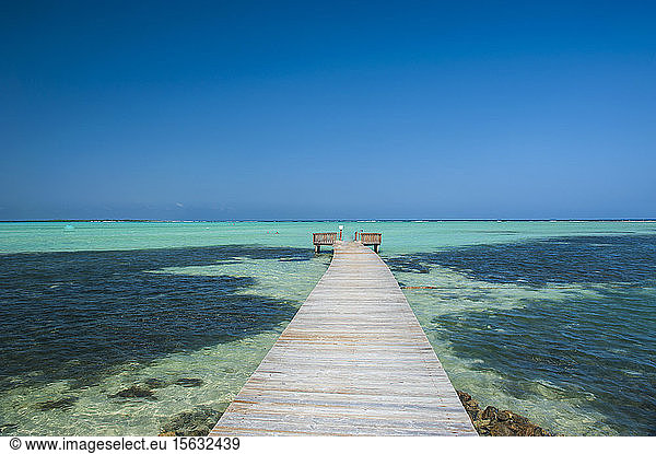 Diminishing perspective of pier in Lac Bay against clear blue sky at Bonaire  Netherlands Antilles