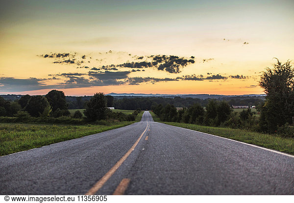 Diminishing perspective of rural road at sunset