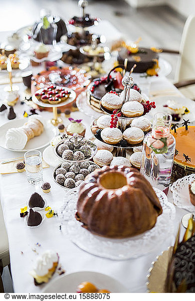 Dining table filled with all kinds of snacks and desserts