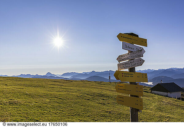 Directional sign in Bavarian Prealps at foggy sunrise