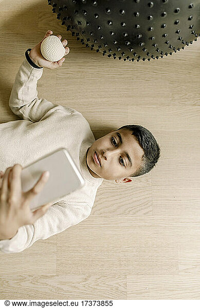 Directly above shot of boy taking selfie through smart phone at home