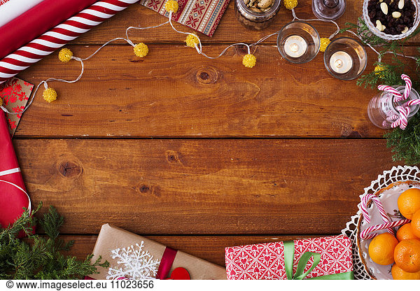 Directly above shot of Christmas decorations and gifts on wooden table