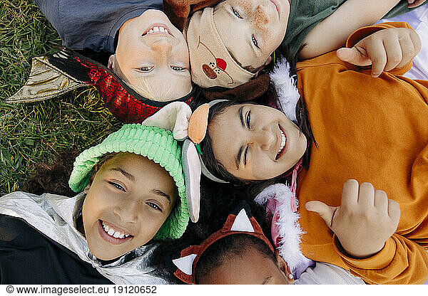 Directly above shot of happy kids lying on grass at summer camp